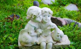 A Cute Figurine of a Little Boy and Girl in a Backyard